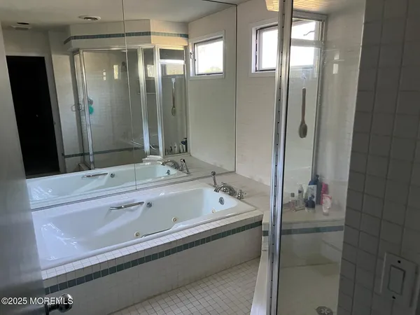 a bathroom with a tub a sink and mirror