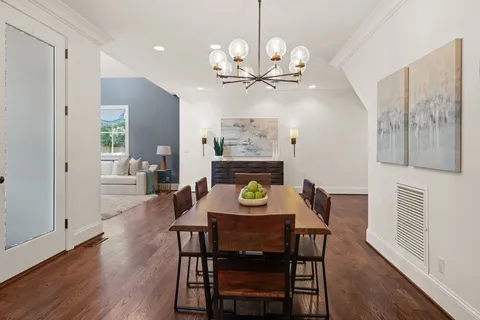 a kitchen with stainless steel appliances kitchen island granite countertop a table chairs sink and wooden floor