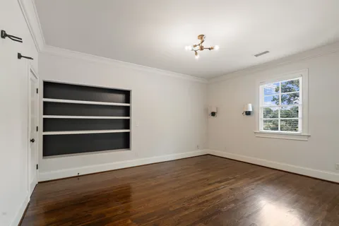 a view of a house next to a big yard and large trees