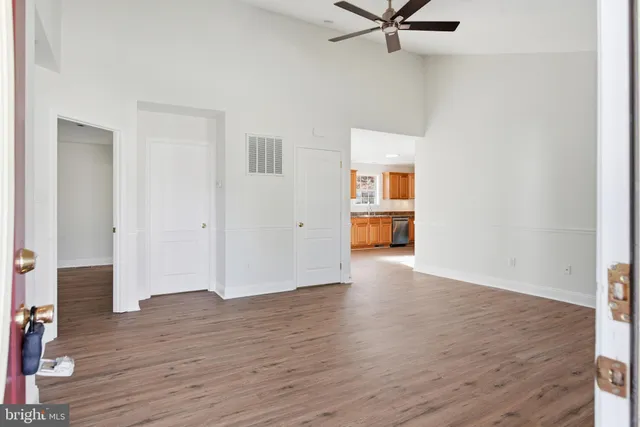 an empty room with wooden floor and windows
