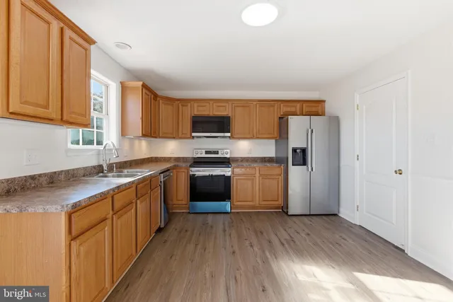 a kitchen with stainless steel appliances a refrigerator sink and cabinets