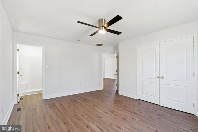 a view of empty room with wooden floor
