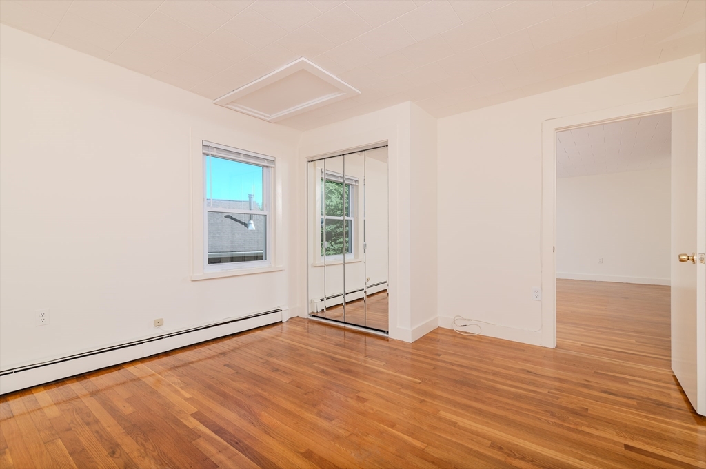 660 Jerusalem Road, Unit 4 Cohasset, MA 02025 - Photo 16 of 20 an empty room with wooden floor and windows