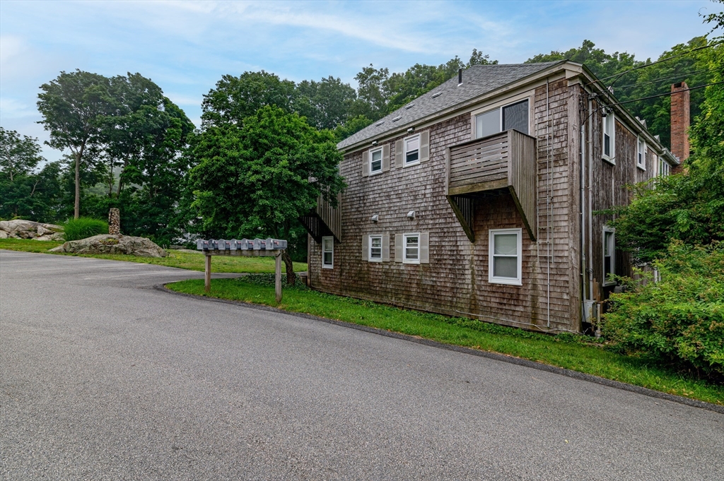 660 Jerusalem Road, Unit 4 Cohasset, MA 02025 - Photo 19 of 20 a front view of a house with a yard and garage