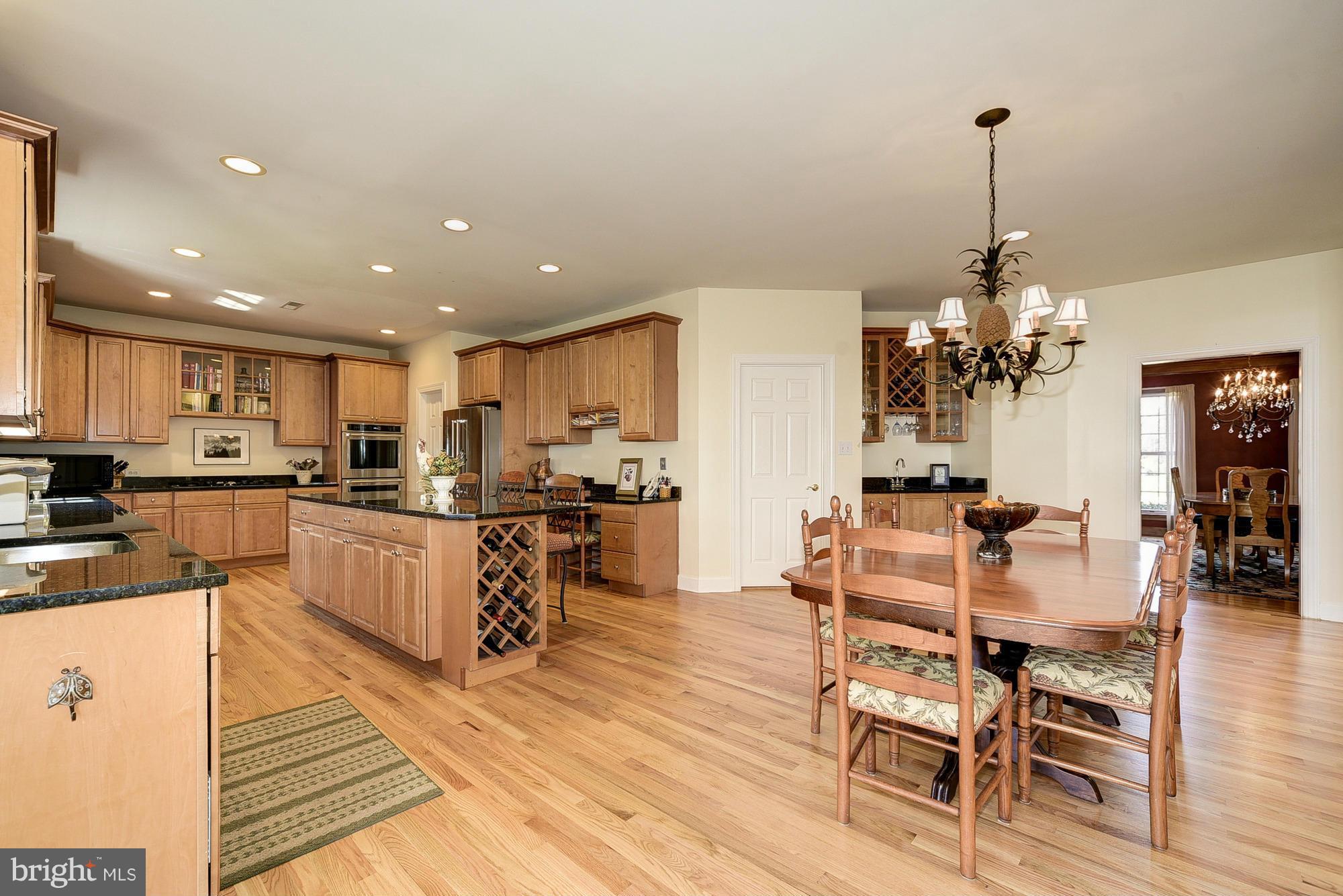 10412 Grey Fox Road Potomac, MD 20854 - Photo 8 of 30 a view of a dining room and livingroom with furniture wooden floor a chandelier