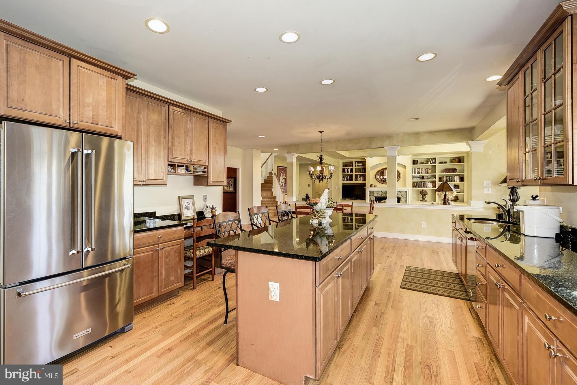 10412 Grey Fox Road Potomac, MD 20854 - Photo 10 of 30 a kitchen with stainless steel appliances a refrigerator a sink a stove and white cabinets with wooden floor