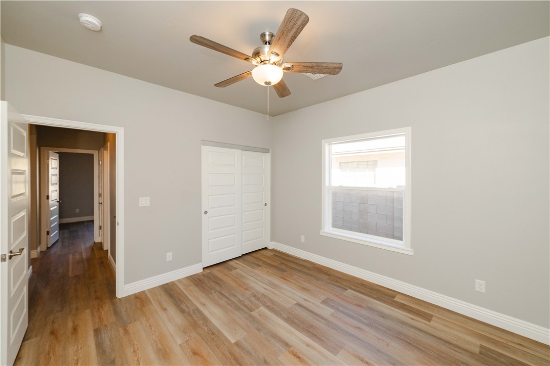 3640 North Kenneth Road Kingman, AZ 86409 - Photo 12 of 44 Unfurnished bedroom with light wood finished floors, a closet, and a ceiling fan