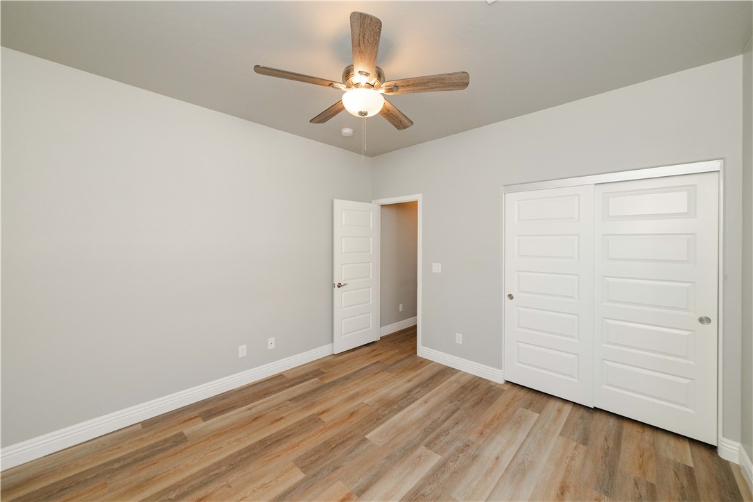 3640 North Kenneth Road Kingman, AZ 86409 - Photo 13 of 44 Unfurnished bedroom featuring light wood finished floors, a closet, and ceiling fan