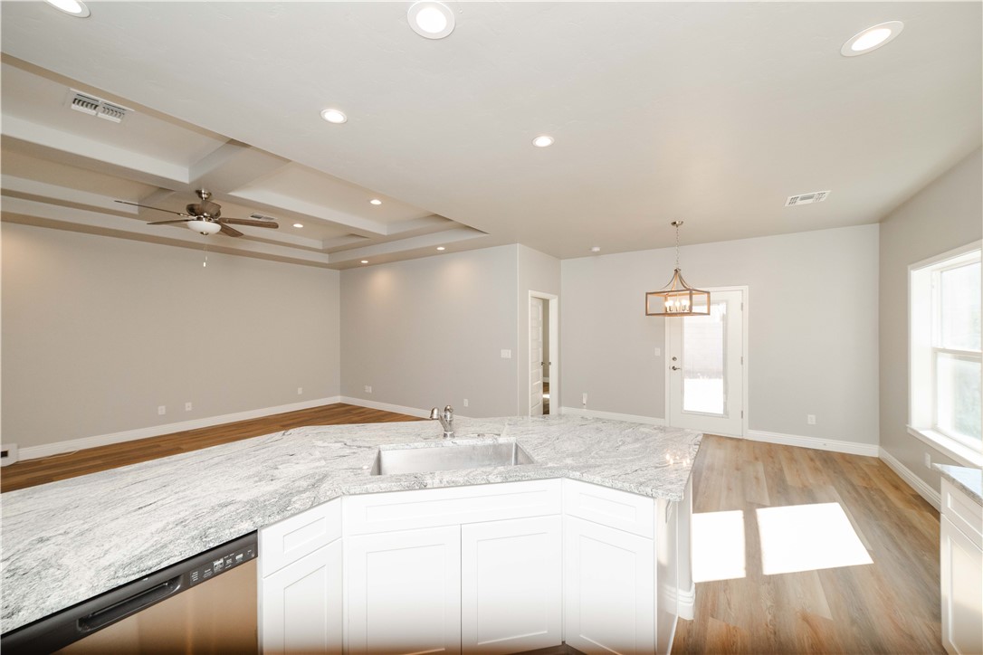 3640 North Kenneth Road Kingman, AZ 86409 - Photo 19 of 44 Kitchen with light stone countertops, light wood finished floors, recessed lighting, stainless steel dishwasher, and white cabinets