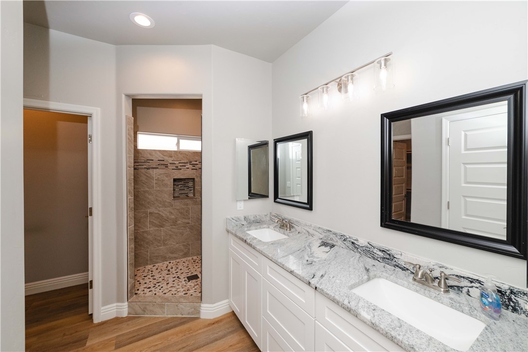3640 North Kenneth Road Kingman, AZ 86409 - Photo 22 of 44 Bathroom with light wood-style flooring, walk in shower, and double vanity
