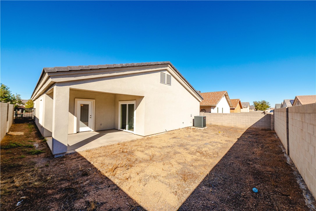 3640 North Kenneth Road Kingman, AZ 86409 - Photo 36 of 44 Back of property with a fenced backyard, stucco siding, and a patio