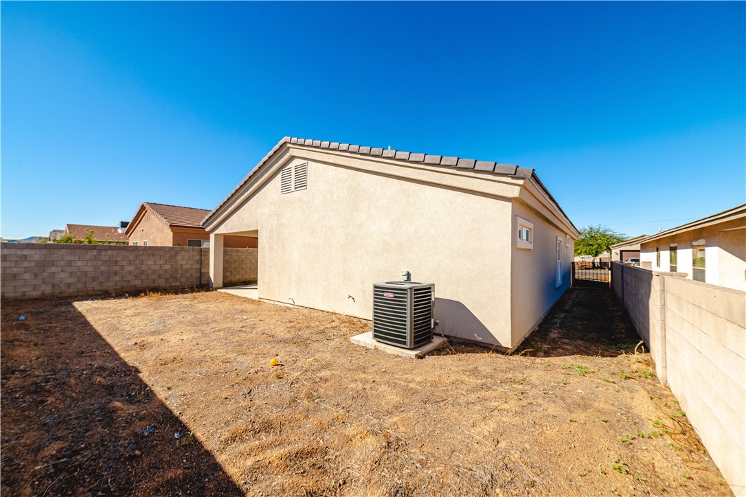 3640 North Kenneth Road Kingman, AZ 86409 - Photo 37 of 44 View of side of home featuring stucco siding, a fenced backyard, and a patio
