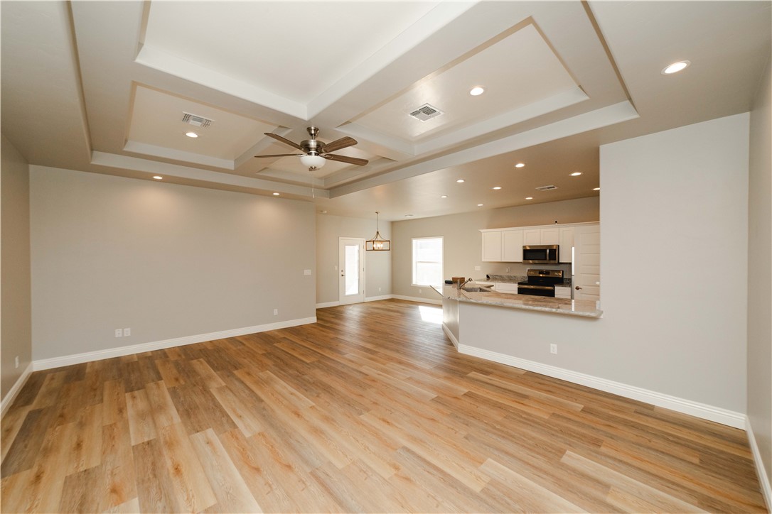 3640 North Kenneth Road Kingman, AZ 86409 - Photo 4 of 44 Unfurnished living room featuring recessed lighting, light wood-type flooring, a ceiling fan, coffered ceiling, and beamed ceiling