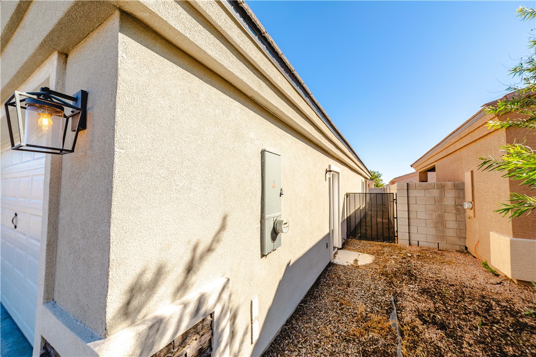 3640 North Kenneth Road Kingman, AZ 86409 - Photo 41 of 44 View of side of home with stucco siding and a gate