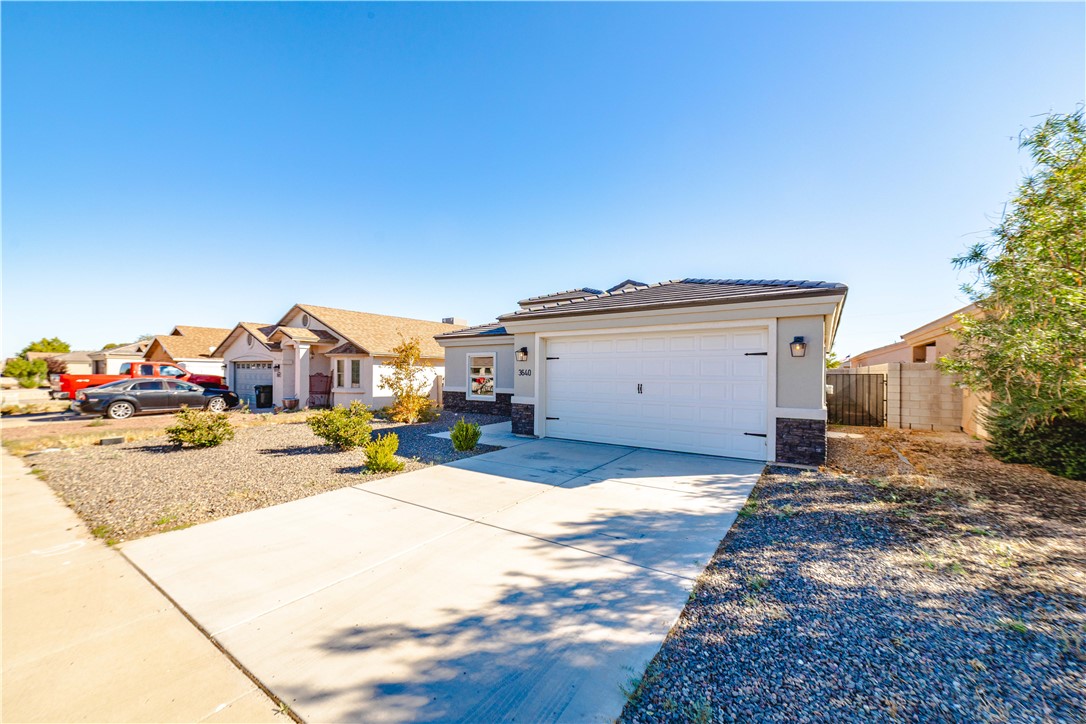 3640 North Kenneth Road Kingman, AZ 86409 - Photo 43 of 44 View of front of property with stone siding, concrete driveway, and a garage