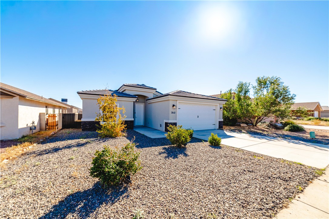 3640 North Kenneth Road Kingman, AZ 86409 - Photo 44 of 44 Prairie-style house with stucco siding, driveway, a garage, and a tiled roof