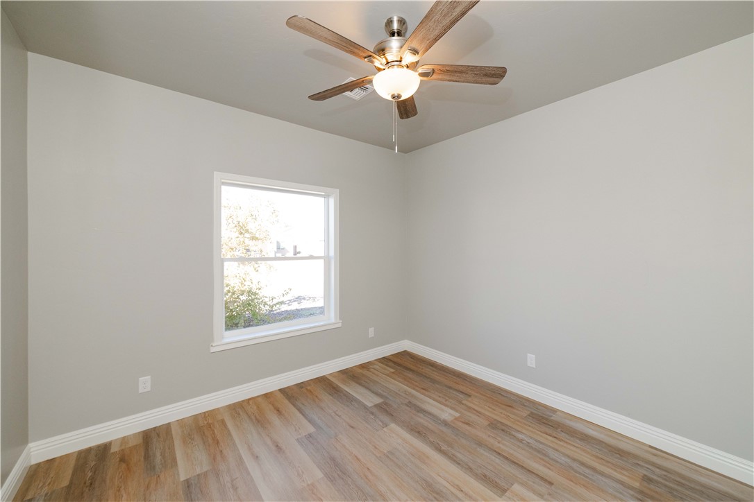 3640 North Kenneth Road Kingman, AZ 86409 - Photo 6 of 44 Empty room with light wood-style floors and a ceiling fan