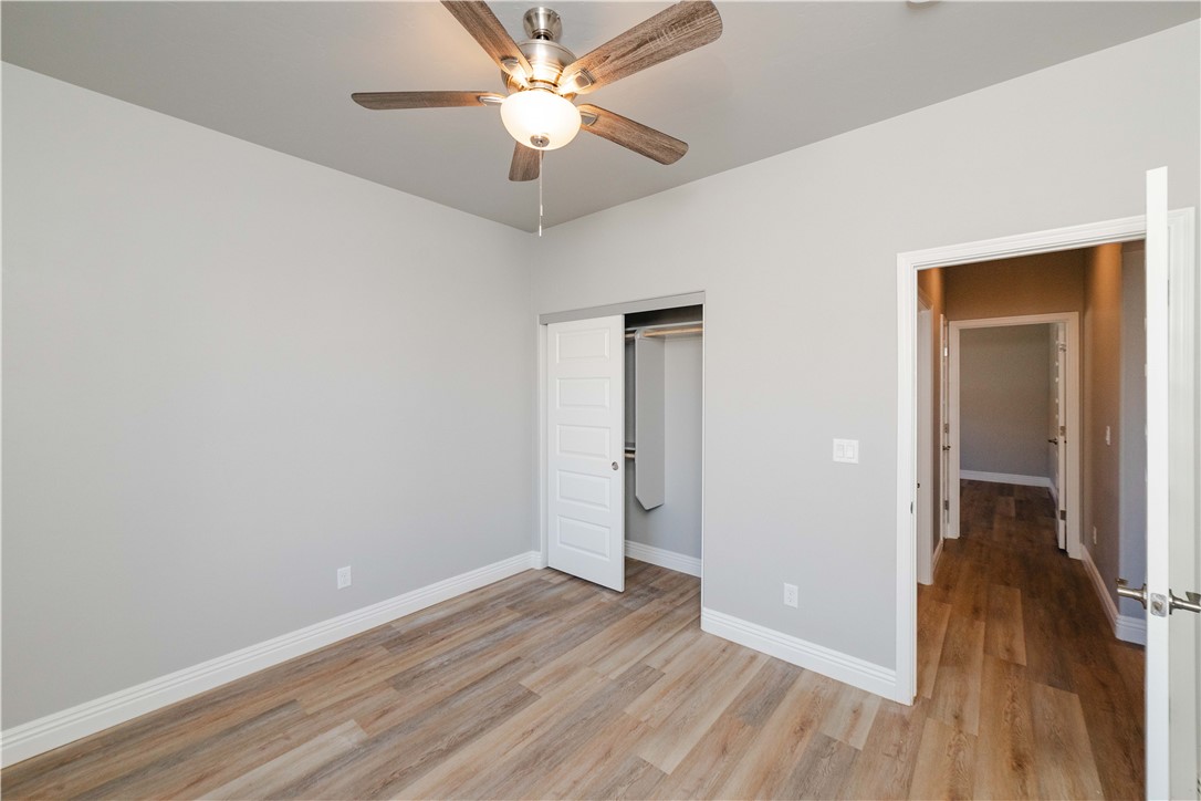 3640 North Kenneth Road Kingman, AZ 86409 - Photo 7 of 44 Unfurnished bedroom with light wood-style flooring, a closet, and a ceiling fan