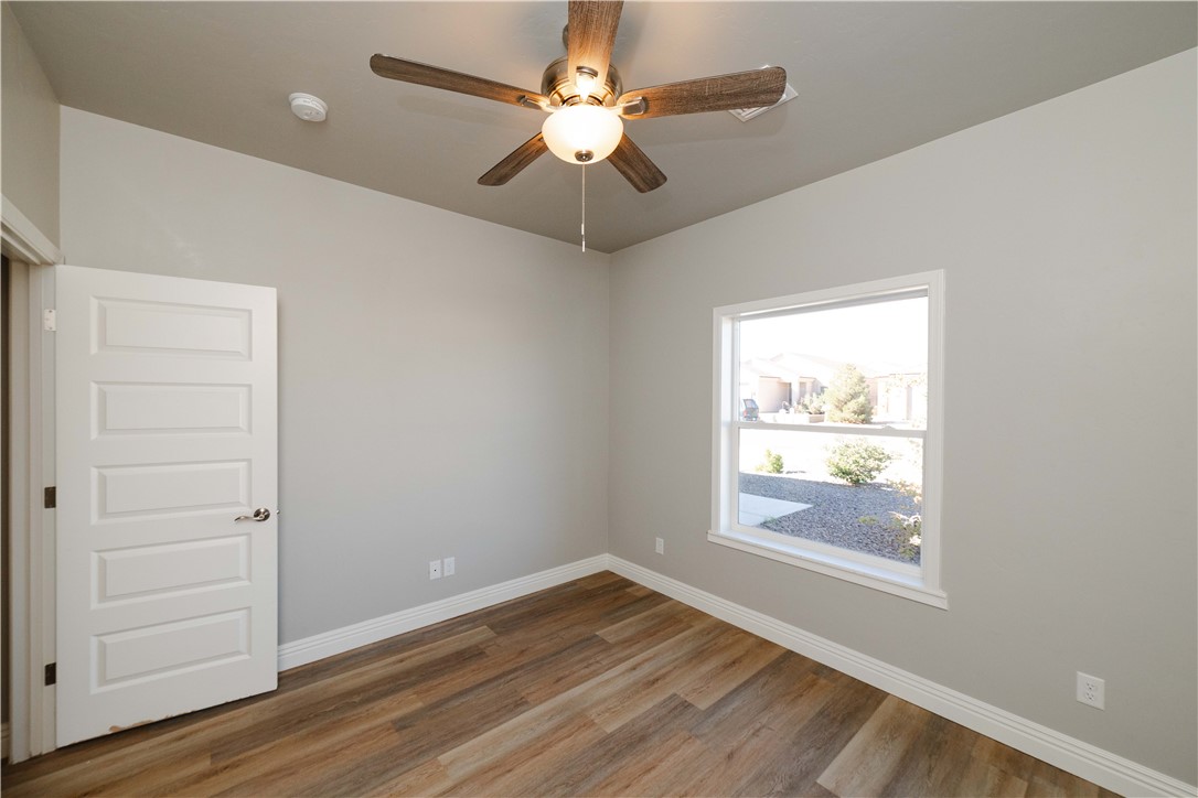3640 North Kenneth Road Kingman, AZ 86409 - Photo 9 of 44 Empty room with wood finished floors and ceiling fan