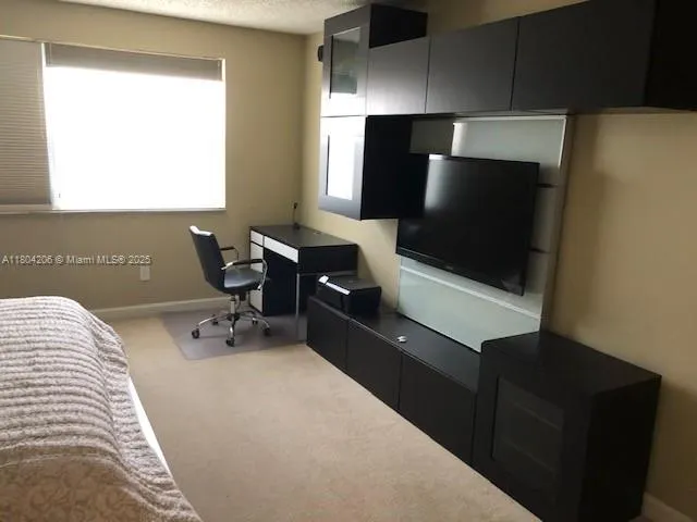 a bedroom with a bed and flat screen tv