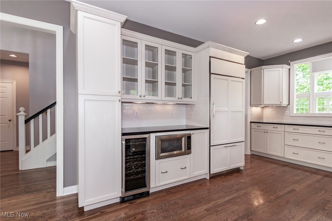 293 Burwick Road Cleveland, OH 44143 - Photo 10 of 50 Kitchen with wine cooler, backsplash, glass insert cabinets, dark wood-style flooring, and recessed lighting