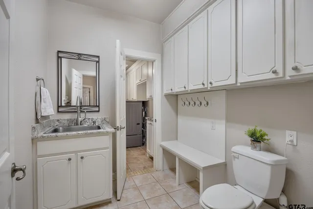 a bathroom with a granite countertop toilet sink and mirror