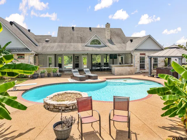 a view of a house with swimming pool and a yard