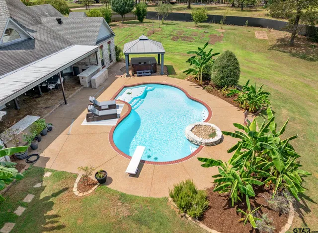 an aerial view of a swimming pool with a yard