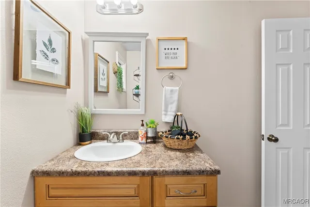 a bathroom with a granite countertop sink and a mirror