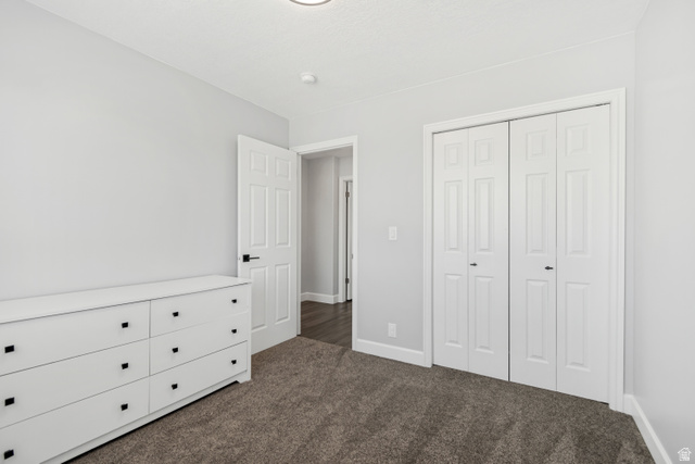 4752 South 4075th Street West Roy, UT 84067 - Photo 17 of 28 Neutral wall tones with dark carpet flooring, white trim, and a bi-fold closet