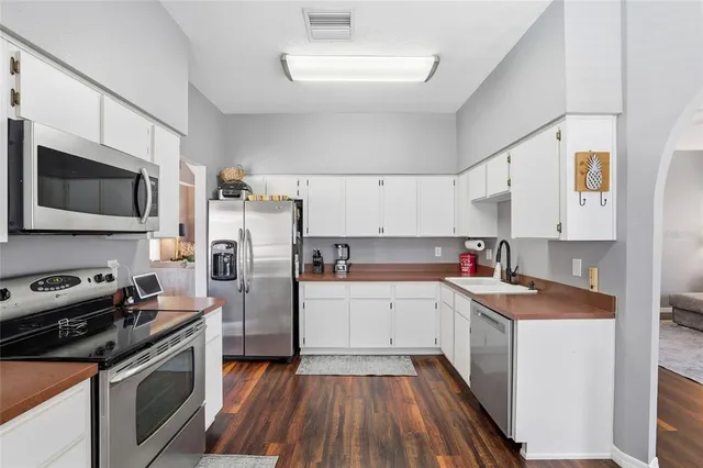a kitchen with stainless steel appliances a stove sink microwave and cabinets