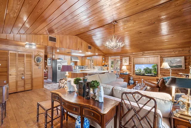 an aerial view of a house with a yard and trees all around