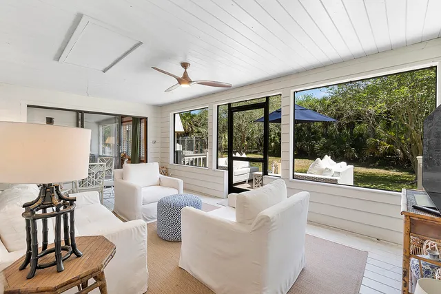 a view of a house with large tree and wooden fence