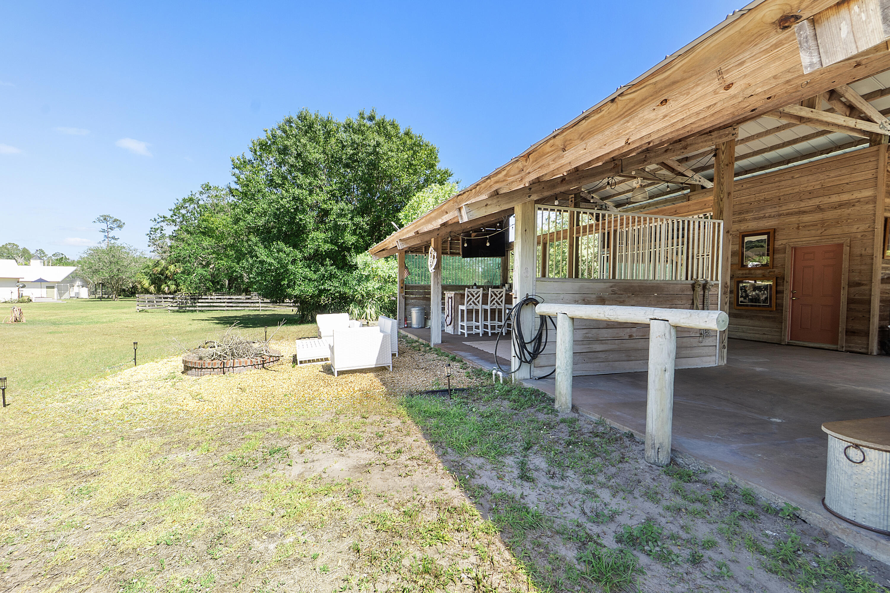 32801 Highway 441, Unit 64 Okeechobee, FL 34972 - Photo 49 of 138 a view of a patio with table and chairs and potted plants with wooden fence