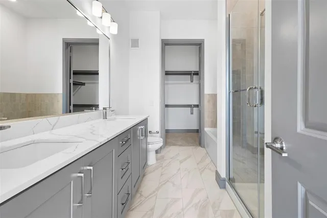 a spacious bathroom with a granite countertop sink mirror and a bathtub