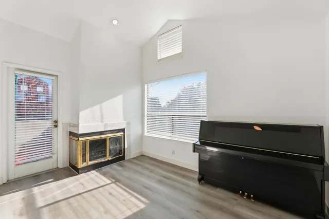 a living room with a fireplace furniture a flat screen tv and windows
