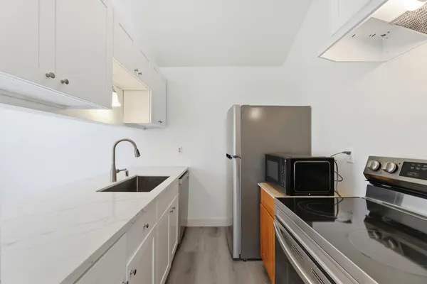 a kitchen with stainless steel appliances kitchen island a sink and refrigerator