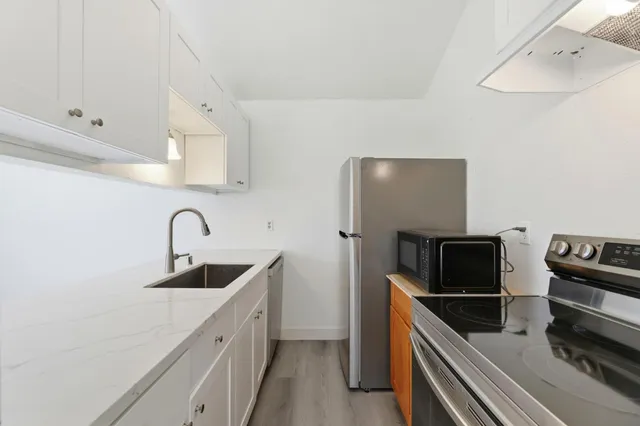 a kitchen with stainless steel appliances kitchen island a sink and refrigerator