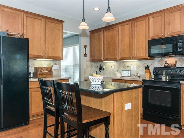 3319 Cathedral Bell Road Raleigh, NC 27614 - Photo 8 of 25 Accented with pendant lighting and granite center island, this kitchen would be agreeable to any chef.