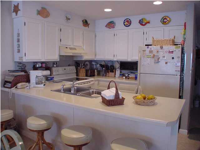 6015 Highway Santa Rosa Beach, Unit A101 30A Santa Rosa Beach, FL 32459 - Photo 12 of 18 a kitchen with a sink a stove and cabinets