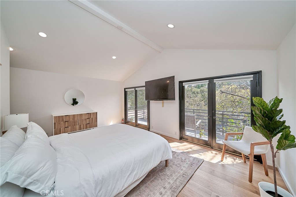 8457 Ridpath Drive Los Angeles, CA 90046 - Photo 12 of 33 a bedroom with a large bed and a flat tv screen