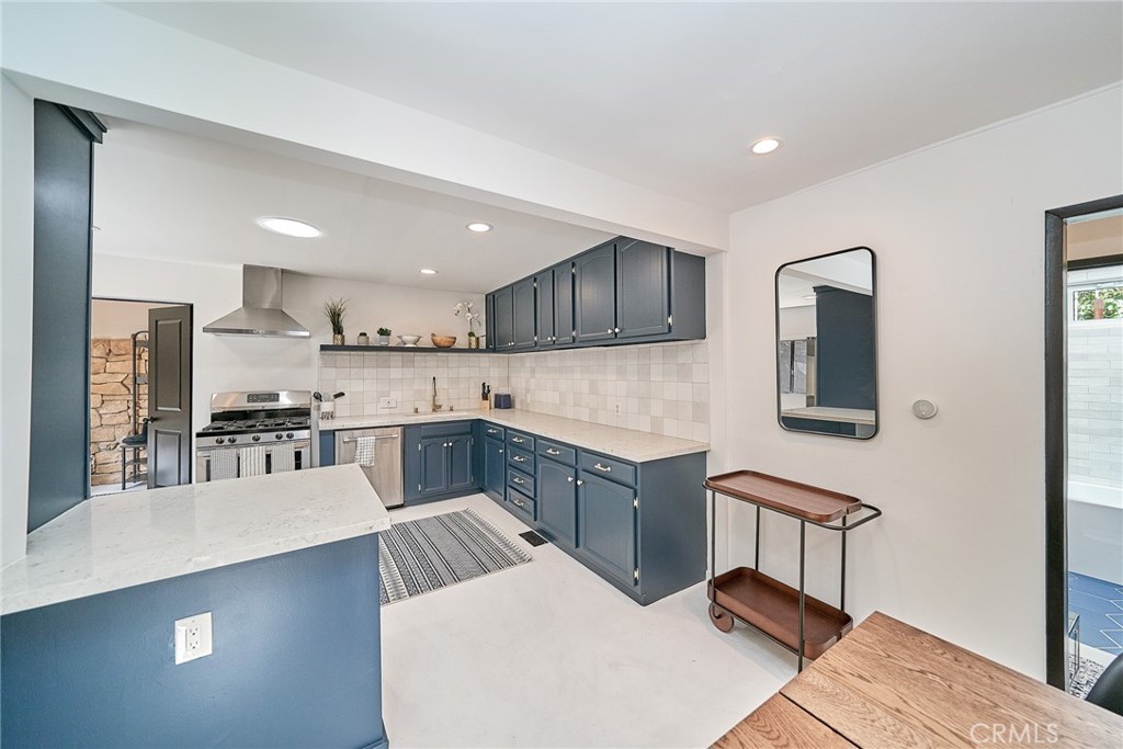 8457 Ridpath Drive Los Angeles, CA 90046 - Photo 16 of 33 a kitchen with stainless steel appliances kitchen island granite countertop a sink and a refrigerator