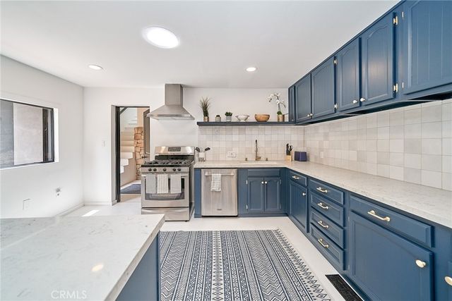 a kitchen with stainless steel appliances granite countertop a stove a sink and a microwave