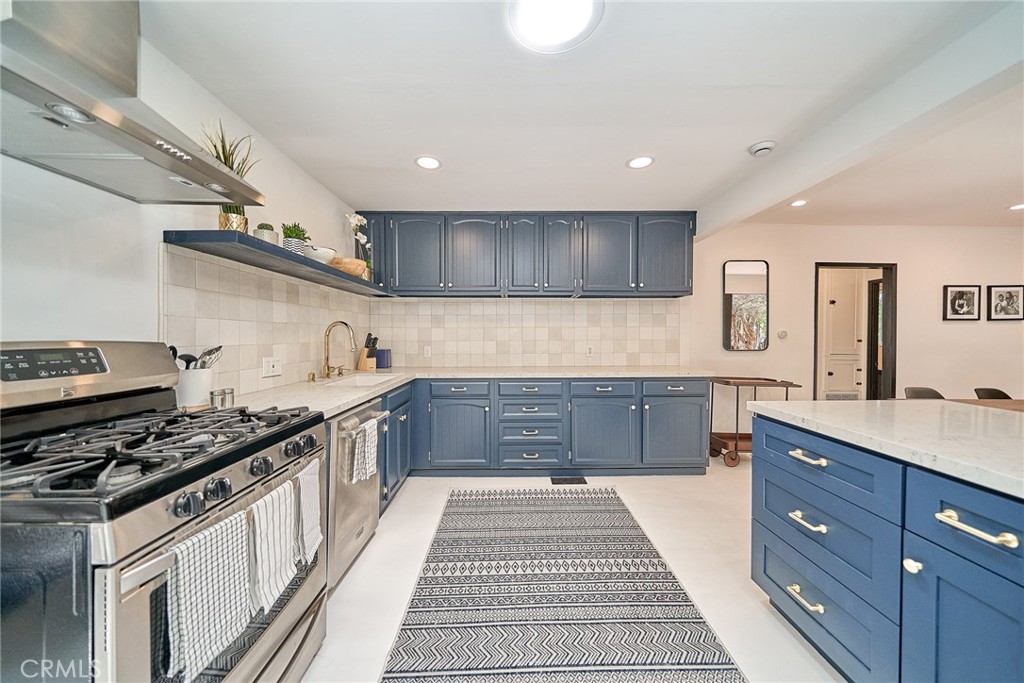 8457 Ridpath Drive Los Angeles, CA 90046 - Photo 19 of 33 a kitchen with stainless steel appliances granite countertop a stove a sink and a microwave