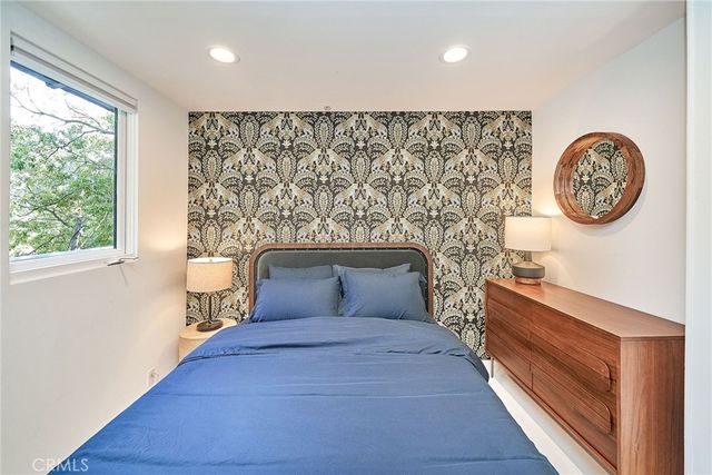 a bedroom with a bed and a large window