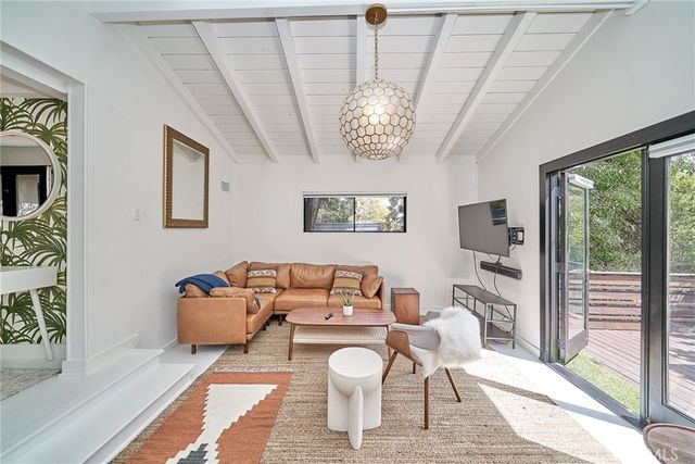 a living room with furniture a chandelier and a large window