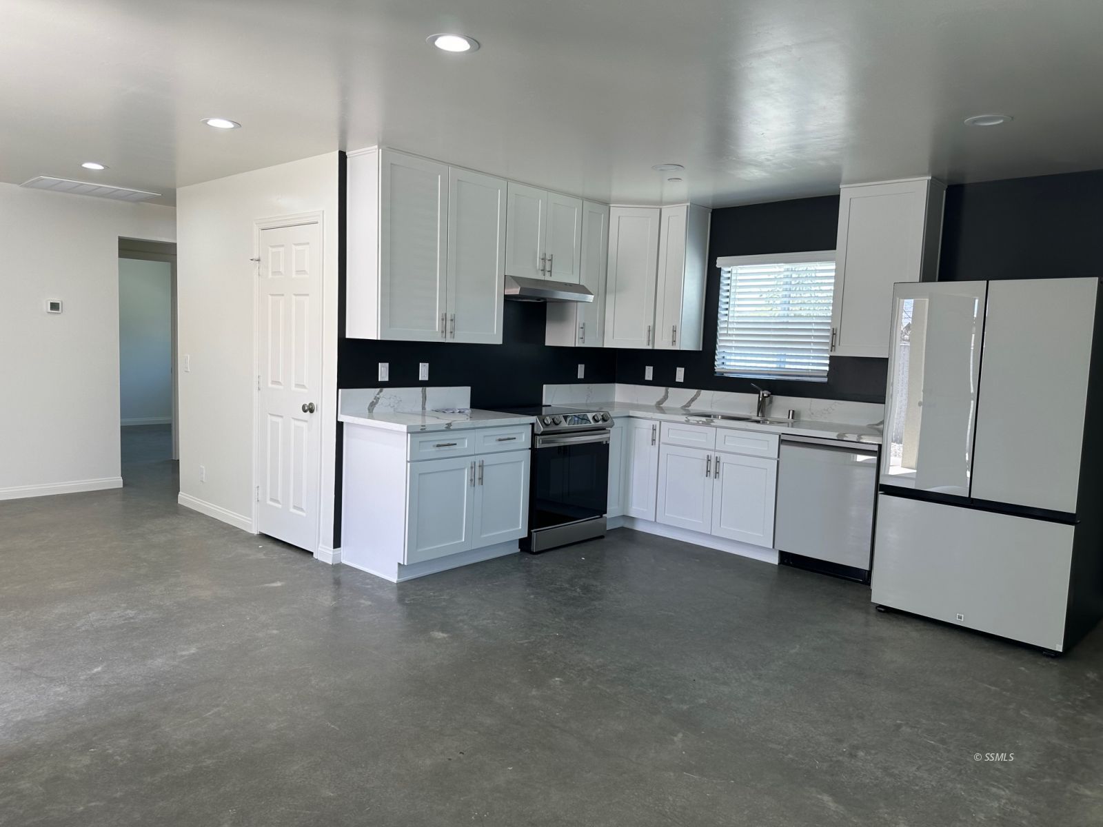223 West Haloid Avenue Ridgecrest, CA 93555 - Photo 4 of 9 a kitchen with stainless steel appliances a refrigerator sink and white cabinets