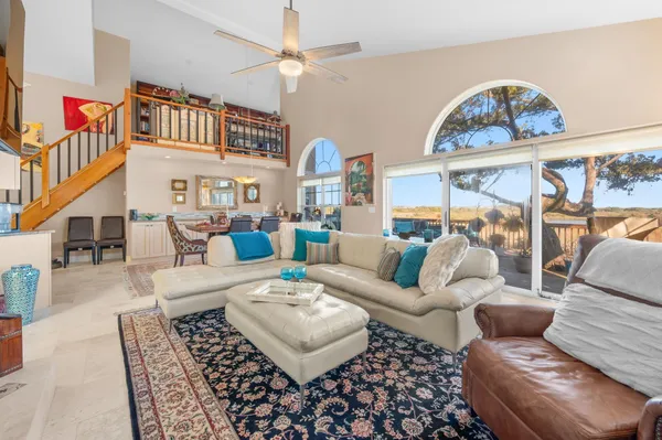 a view of a livingroom with furniture a fireplace wooden floor and windows
