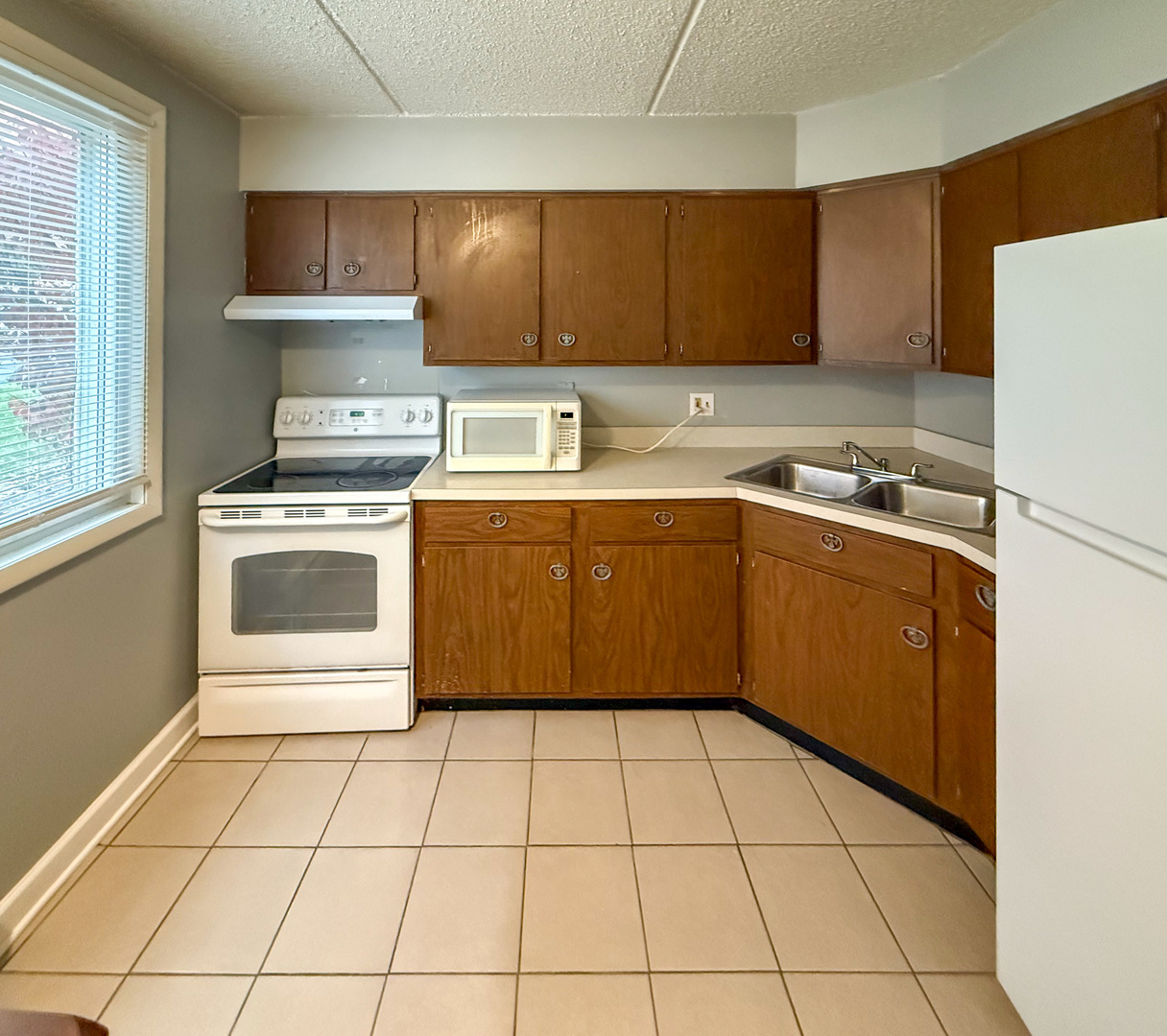 6305 Joliet Road, Unit 11 Countryside, IL 60525 - Photo 5 of 6 a kitchen with a cabinets sink and white stainless steel appliances