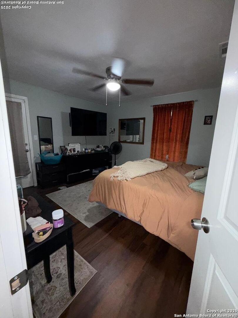 433 West Adams Street Pleasanton, TX 78064 - Photo 11 of 13 a bedroom with a bed a flat screen tv and a chandelier